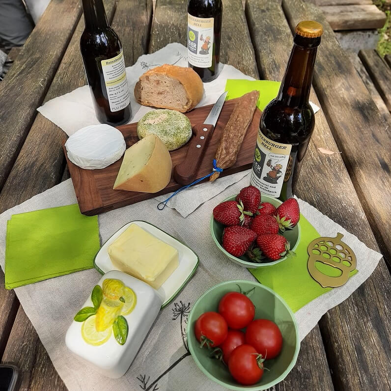 Picknick mit Käse, Wurst, Obst und einem kühlen Bier.
