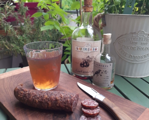 Gintonic und Wildwurst auf einem Brett serviert