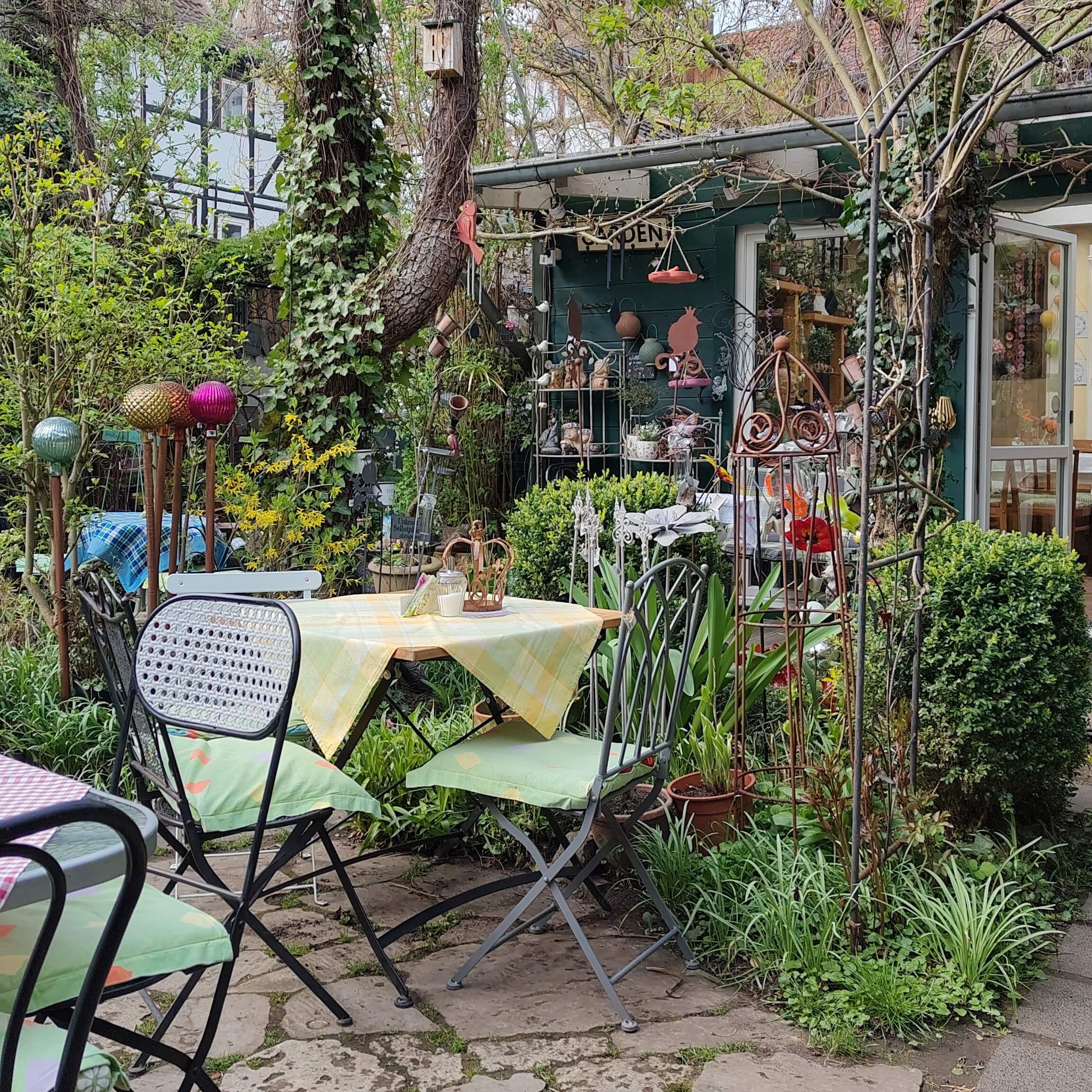 Garten mit vielen Decoelementen, Tischen und Stülen des Garten-Cafe Haase